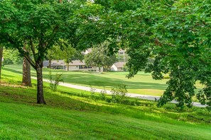 Ein Golfplatz mit Clubhaus und Wohnhäusern im Hintergrund.