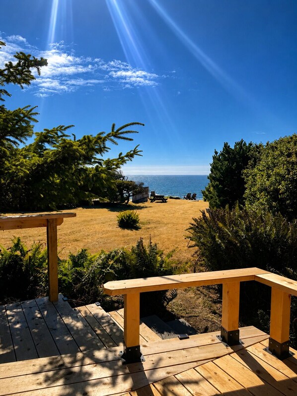 A wooden deck with a view of the beach and ocean.