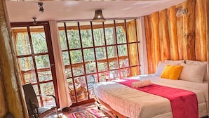 A room with a bed, a chair, a window, and a wooden floor. - Eco Quechua  (Santa Teresa)