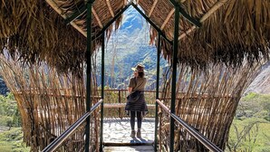 A wooden bridge with a thatched roof leading to a mountainous landscape. - Eco Quechua  (Santa Teresa)