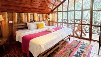 A wooden interior with a bed, a window, and a ceiling light.