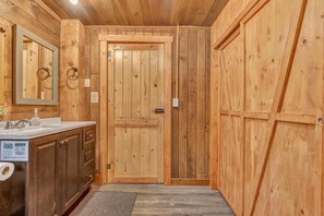 A wooden interior with a sink, mirror, and a door with a sign. - Rancho McCrea Retreat is your perfect Yellowstone Vacation destination! Dogs ok (Island Park)