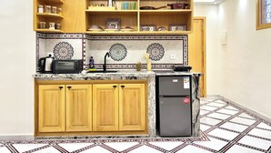 Una cocina con armarios de madera, un refrigerador y salpicadero de azulejos.