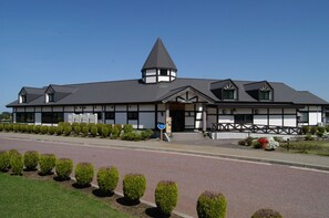 A two-story building with a gabled roof and a central tower.