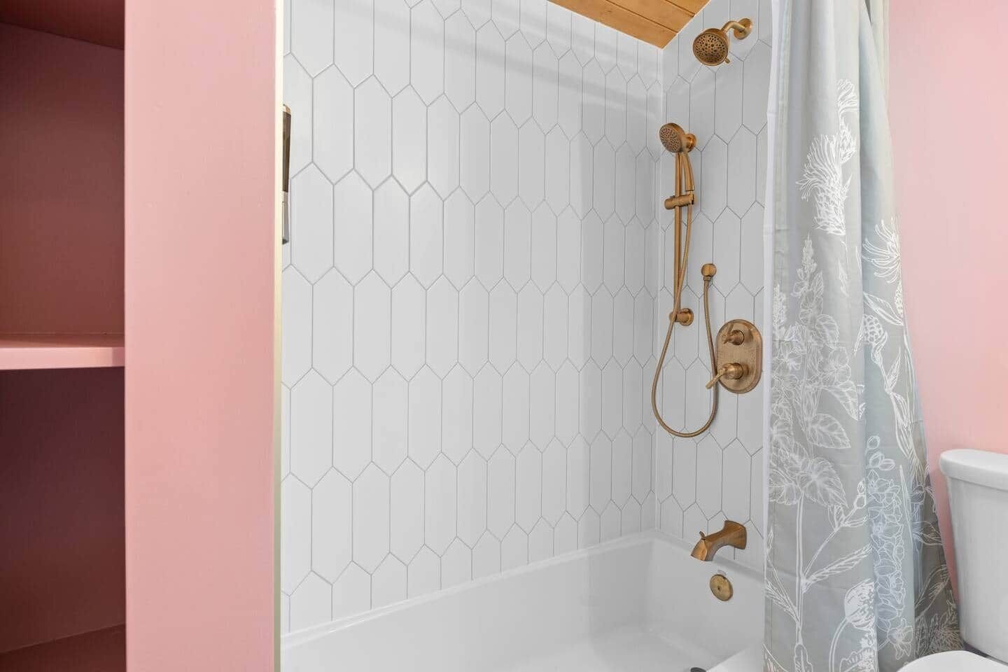 Une douche avec un carrelage à motifs hexagonaux et un pommeau de douche.