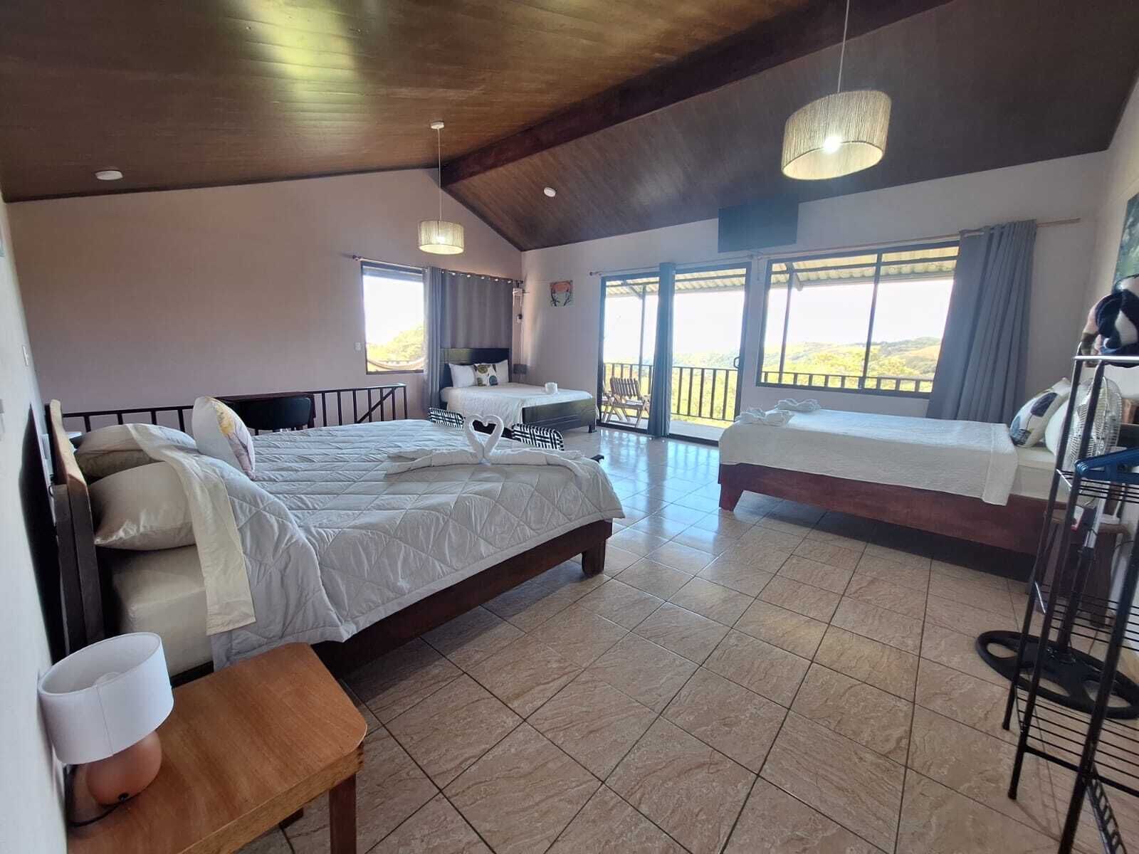 Une chambre d’hôtel avec deux lits, un balcon et une vue sur l’extérieur.