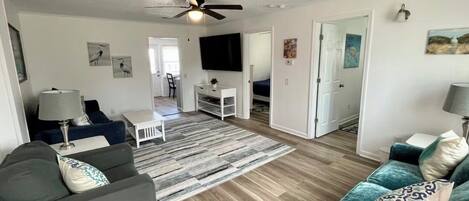 A living room with a ceiling fan, a TV, and a coffee table.