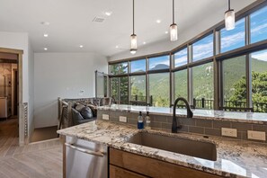 A modern kitchen with a large window, granite countertop, and stainless steel appliances. - Aspen Trail Retreat - Breathtaking Mountain Views! (Estes Park)