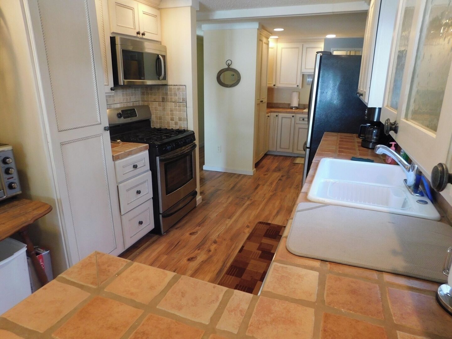 A compact kitchen with a microwave, stove, and sink.