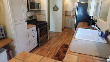 A compact kitchen with a microwave, stove, and sink.