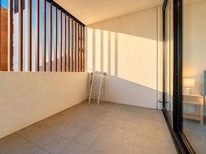 A corner room with a tiled floor, a metal rack, and a glass door leading to another room. - Gordon 2BR Apt Walk to Station & Shops (Gordon)