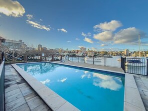 Ein Pool mit Blick auf eine Marina und Gebäude im Hintergrund.