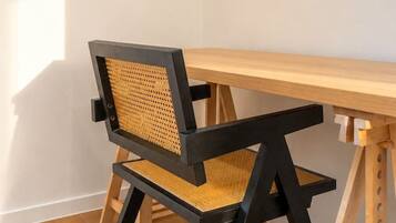 A corner room with a wooden desk and a black and brown chair.