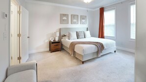 Un dormitorio con cama, mesita de noche, lámpara y decoración en la pared.