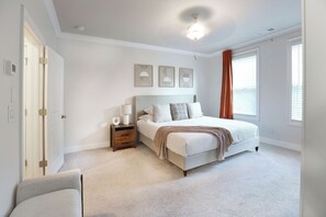 Ein Schlafzimmer mit Bett, Nachttisch, Lampe und Wandbild.