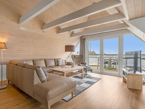 A modern living room with a sofa, coffee table, and a TV. - "Algut" - 200m from the sea by Interhome (Blåvand)