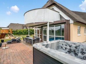 Il s’agit d’une propriété résidentielle dotée d’un mur extérieur incurvé, d’un jacuzzi et d’un espace patio aménagé avec du mobilier d’extérieur.