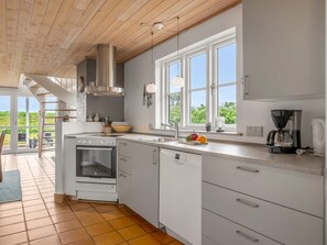 Une cuisine moderne équipée d’une cuisinière, d’un four, d’un lave-vaisselle et d’une machine à café.
