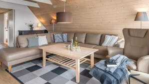 Ett modernt vardagsrum med en soffa, ett soffbord och lampor.