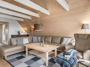 Ein modernes Wohnzimmer mit einer Couch, einem Couchtisch und Lampen.