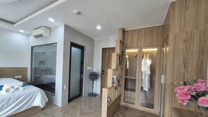 A hotel room with a bed, a walk-in closet, a fan, and a shower. - LANA SEA (An Thoi)