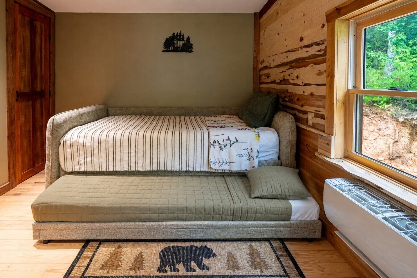 Una habitación acogedora con una cama, una ventana y un tapiz de piel de oso.