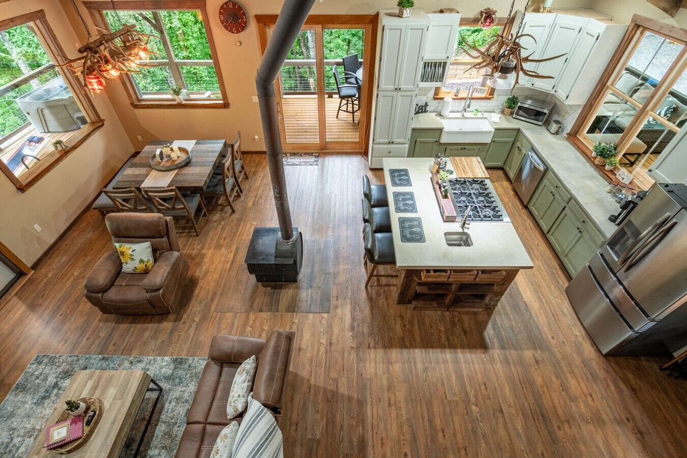 Una cocina moderna con una isla central, suelo de madera y un amplio ventanal con vistas a una terraza.
