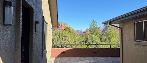 A building with a patio area, a door, and a view of mountains.