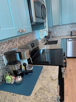 A kitchen with a built-in stove, a coffee maker, and a microwave. - Blue Lagoon • New Luxury Beach Villa  • Sleeps 5 (Galveston)