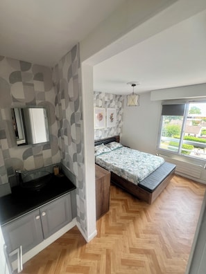 A bedroom with a bed, a window, a sink, and a mirror. - Valéssia Home: Spacious 100 m² apartment near Disneyland Paris with free parking (Meaux)