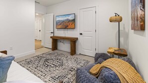 A modern bedroom with a bed, a wooden bench, a patterned rug, and a painting on the wall. - Mountain Haus, Hot Tub, Sauna, Deer Valley Close (Heber City)