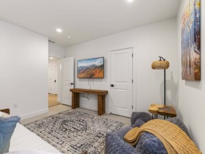 A modern bedroom with a bed, a wooden bench, a patterned rug, and a painting on the wall. - Mountain Haus, Hot Tub, Sauna, Deer Valley Close (Heber City)