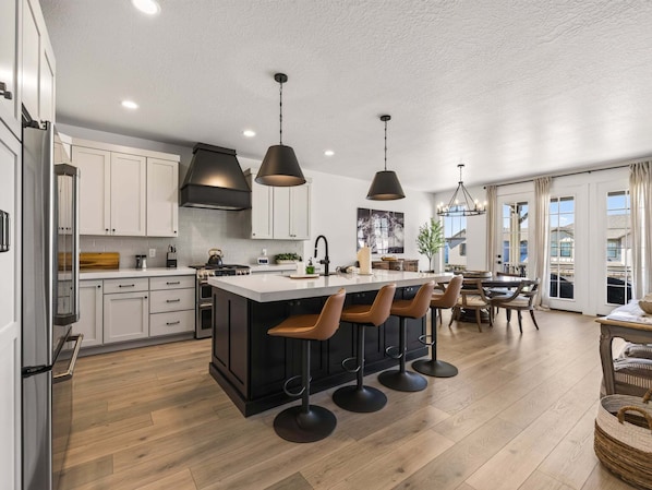 A modern kitchen with a central island, bar stools, and pendant lighting. - Mountain Haus, Hot Tub, Sauna, Deer Valley Close (Heber City)