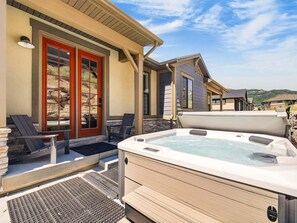 Ein Wellnessbereich mit Whirlpool, Sitzgelegenheiten im Freien und einer Steinwand.