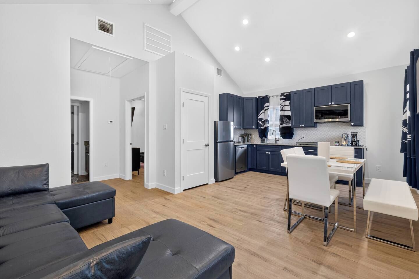 A modern apartment with a living room, dining area, and kitchen.