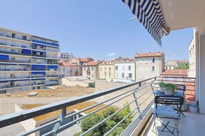 A balcony with a view of a residential area, a metal railing, and a potted plant. - Upstays Studio 28m2 Balcony AC (Cannes)