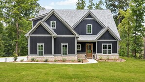 A two-story house with a symmetrical facade, a central entrance, and a well-maintained lawn. - Cala Tortuga - Private dock, quiet cove, and games (Sparta)