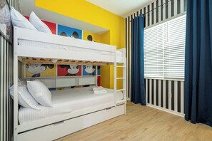 A bunk bed with a lower bunk, a window with blinds, and a wall with colorful artwork. - Cozy 3BR Apartment Storey Lake Resort Near Disney (Kissimmee)