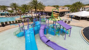 A water park with a purple slide, a pool, and palm trees.