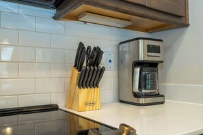 A kitchen with a coffee maker and a knife block on the counter. - 6BR Villa Pool & Lake View Balmoral Resort (Haines City)