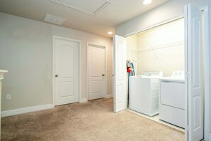 A laundry room with two washing machines, a dryer, and a clothes drying rack. - 6BR Villa Pool & Lake View Balmoral Resort (Haines City)