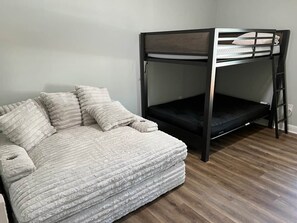 A room with a sofa and a bunk bed. - Island Oasis with Included Golf Cart (Dauphin Island)