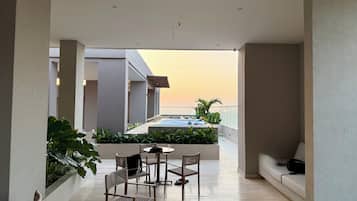 Une terrasse extérieure moderne avec une piscine, un espace salon et des plantes.