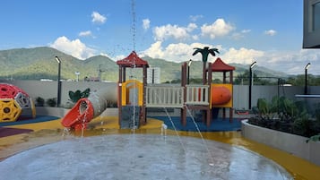 A playground with a water play area, slides, and climbing structures.