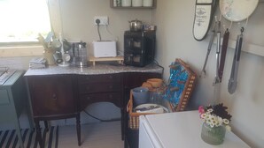 A compact kitchen with a refrigerator, a coffee maker, and a toaster on the counter. - Tiny living on the Wild Atlantic Way (Tralee)