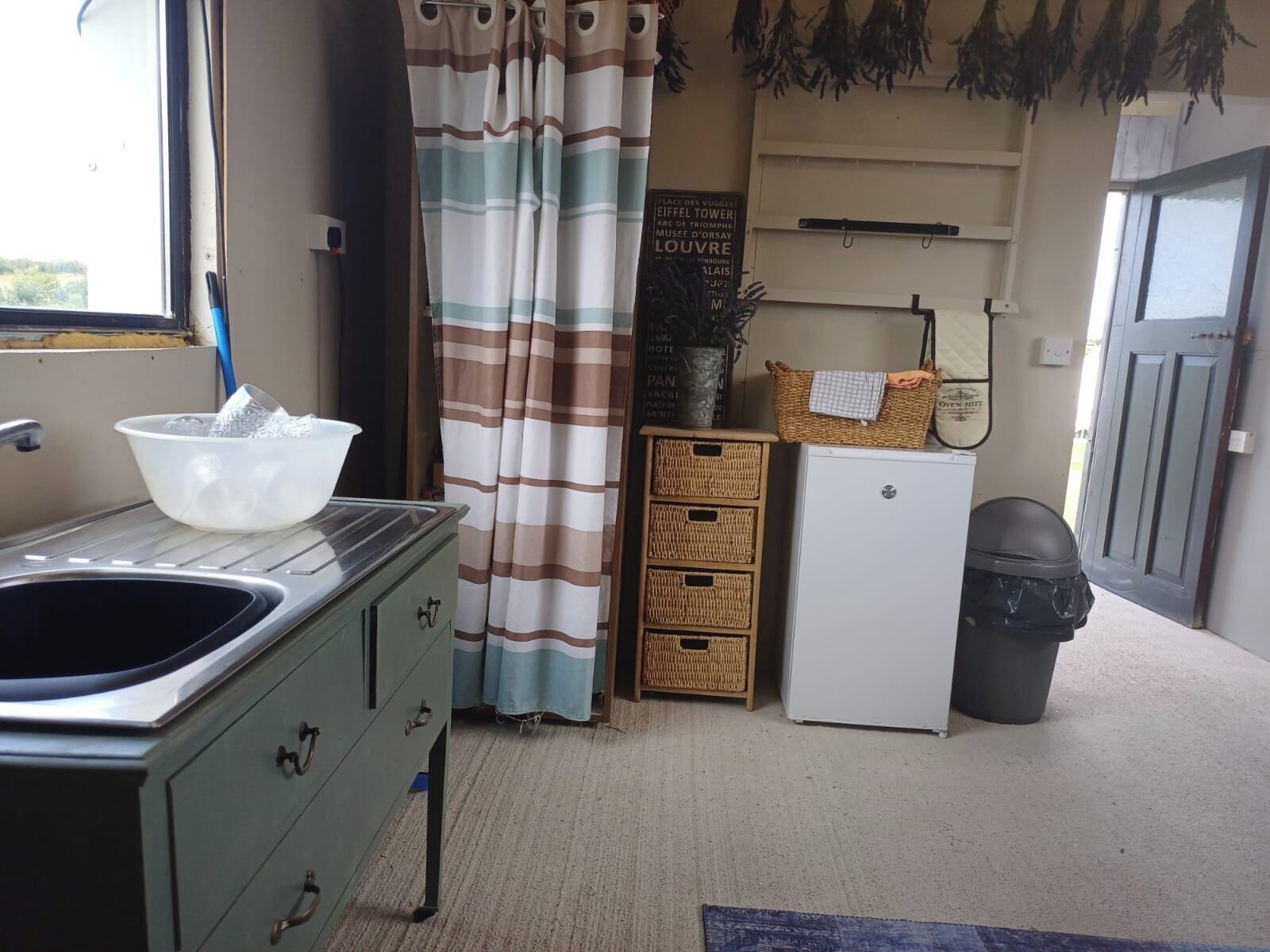 A compact kitchenette with a sink, a small refrigerator, and a cabinet.