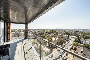 A balcony with a view of a residential area, including houses and parked cars. - Top Floor Penthouse Near Stadium - Free Parking (London)