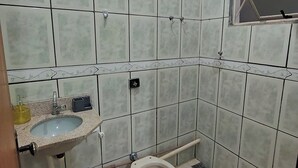Kylpyhuone, jossa on pesuallas, wc ja ikkuna.