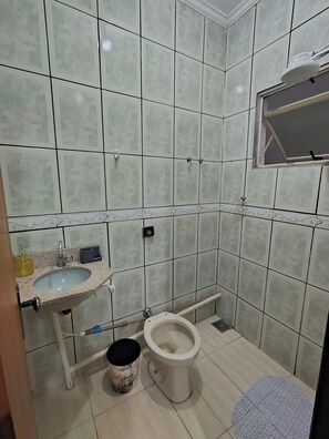 A bathroom with a sink, toilet, and a window.