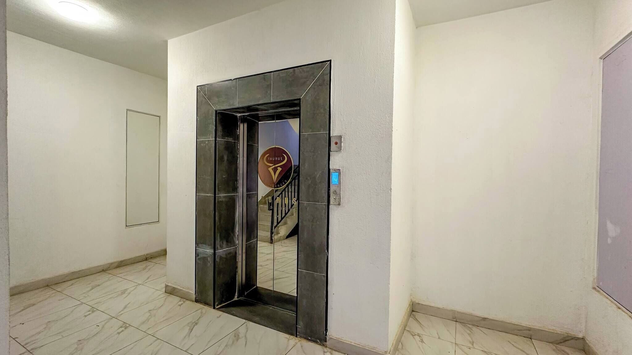 Un pasillo con una puerta espejada que da a una escalera.